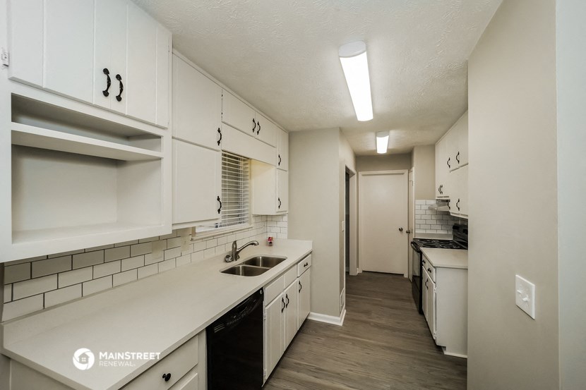 a kitchen with white cabinets and white counters and a sink