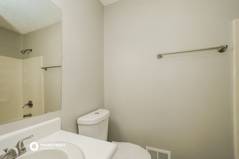 a bathroom with a toilet and a sink and a mirror