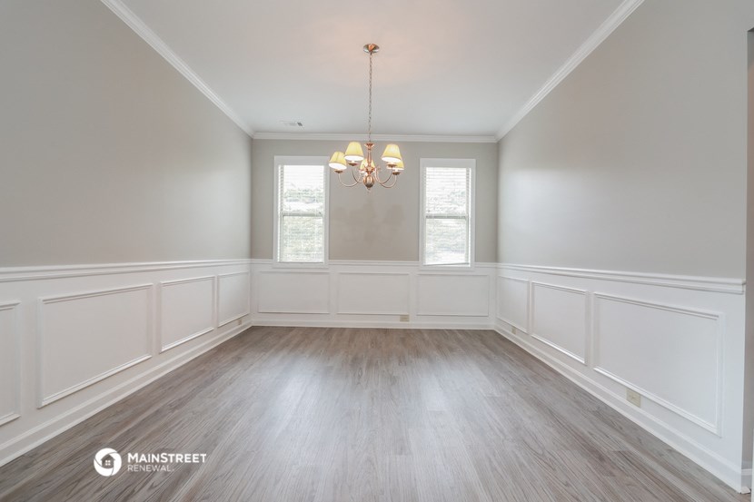 the dining room of a home with white walls and wood floors