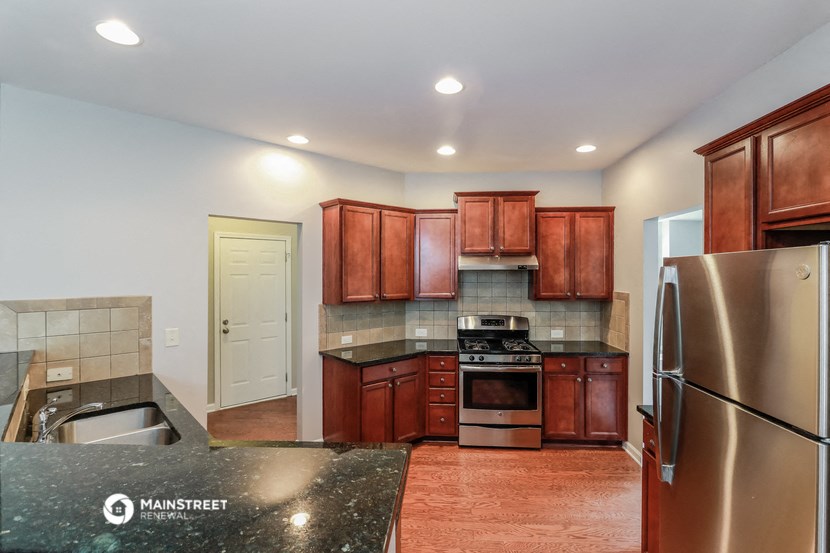a kitchen with wooden cabinets and stainless steel appliances and granite counter tops