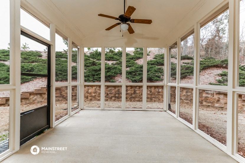 a view of the screened in porch from the interior of a sun room with windows