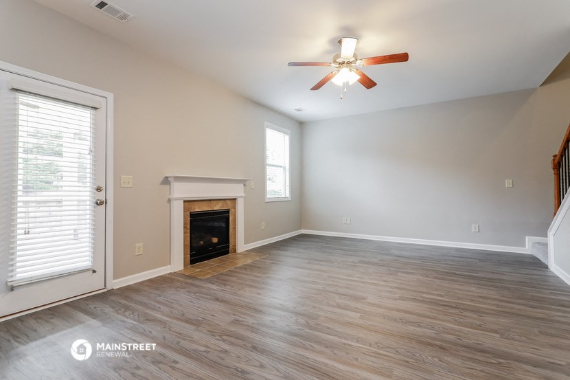 the living room with fireplace and ceiling fan