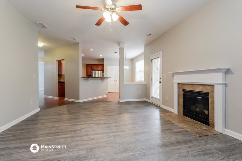 a living room with a fireplace and a ceiling fan