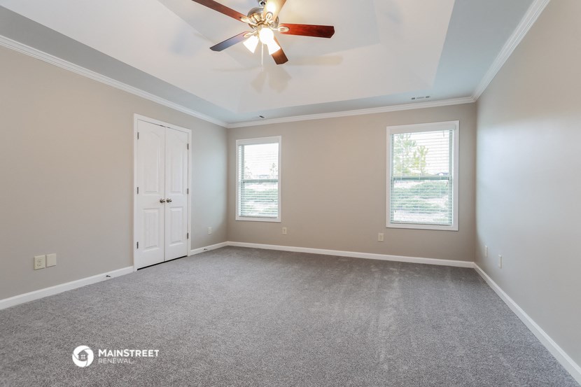 the living room of an empty house with a ceiling fan