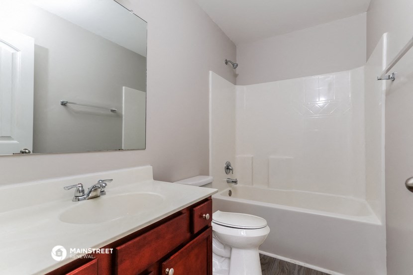 a bathroom with a sink toilet and mirror and a tub