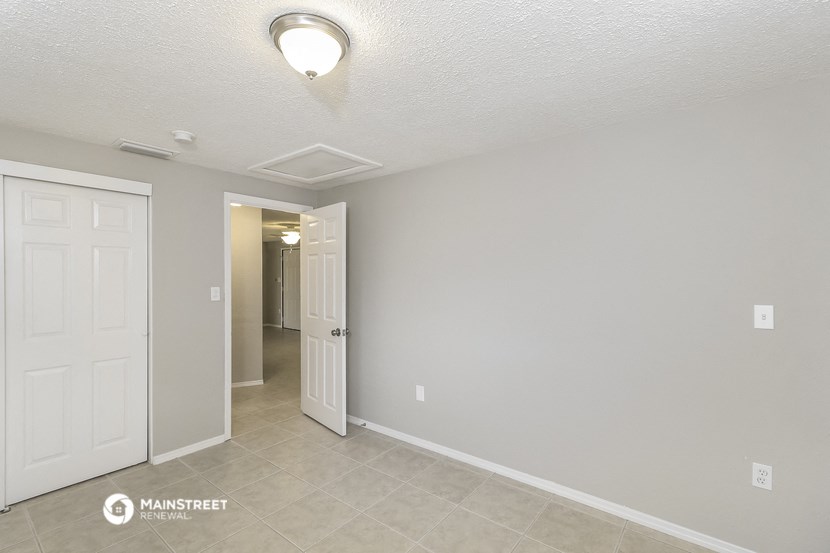 the spacious living room and hallway of a manufactured home with a door to the closet