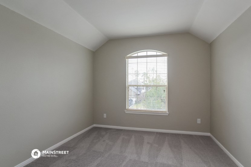 the living room of an empty house with a large window