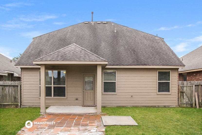 the front of a tan house with a gray roof