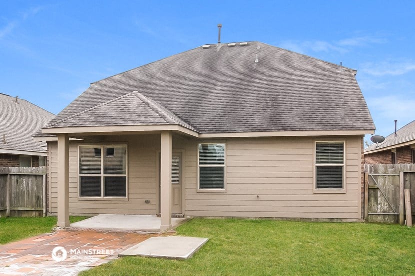 the front of a tan house with a grey roof