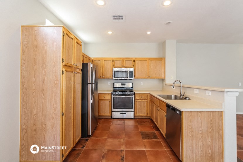 a kitchen with wooden cabinets and stainless steel appliances