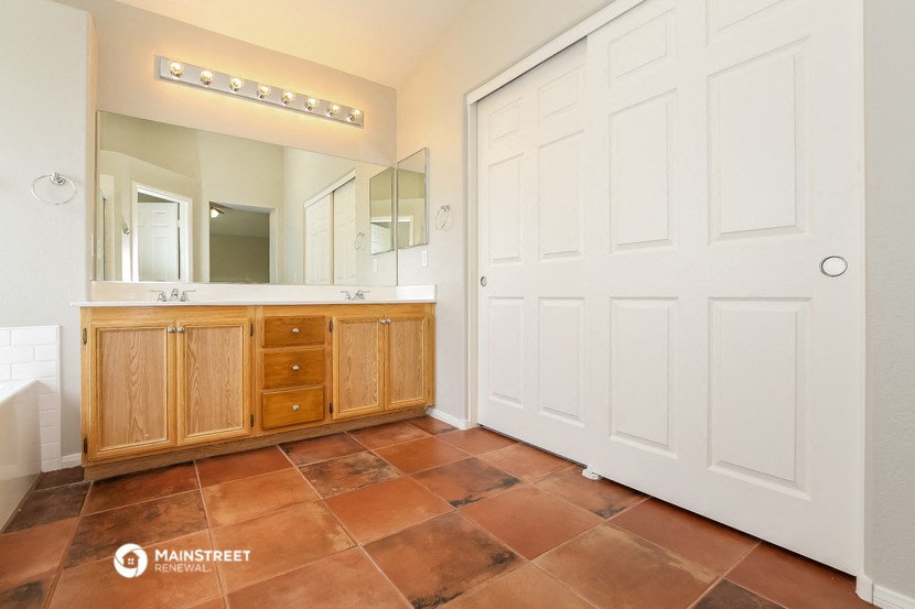 a bathroom with a large white door and a sink and mirror