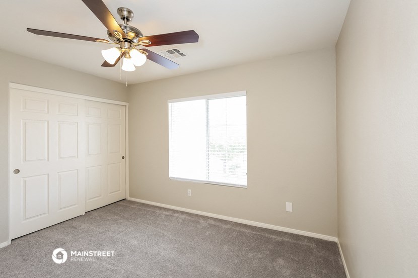 a bedroom with a ceiling fan and a window