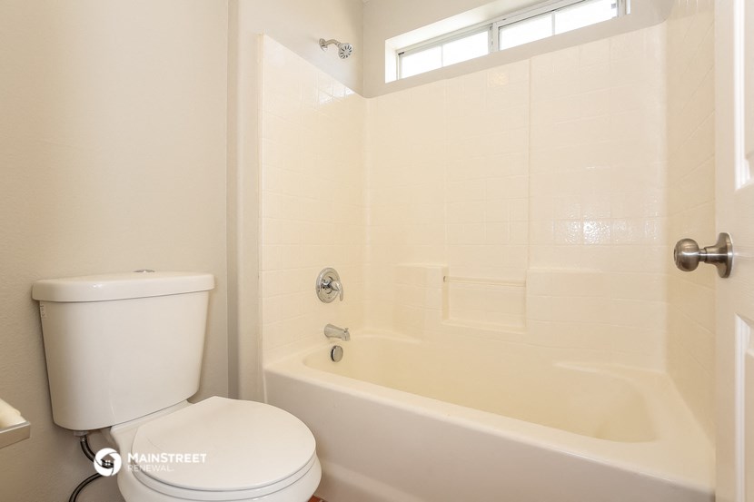 a bathroom with a tub and a toilet and a window