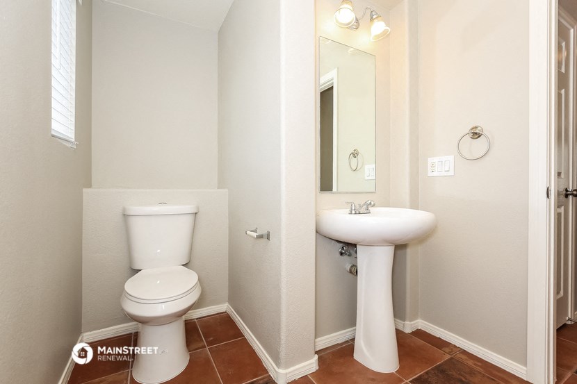 a bathroom with a toilet and a sink and a mirror