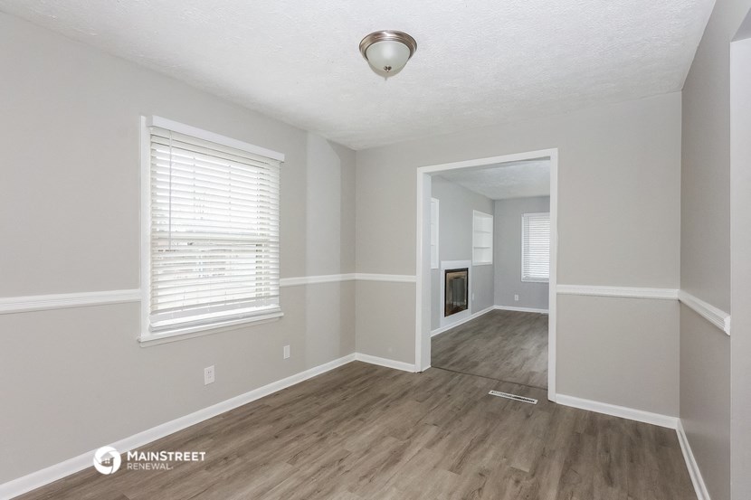 the living room and dining room of an empty house