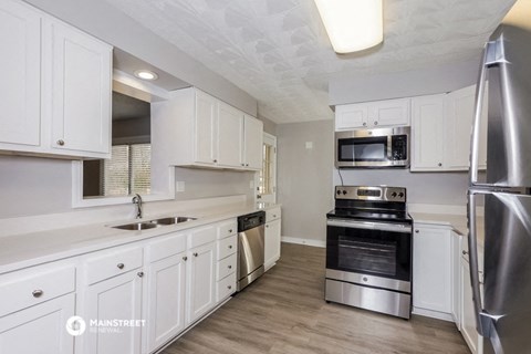 a kitchen with white cabinets and stainless steel appliances