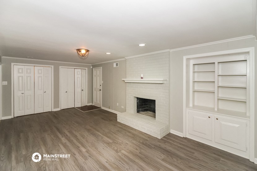 a living room with a fireplace and white shelves