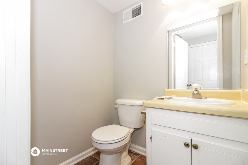 a bathroom with a toilet and a sink and a mirror