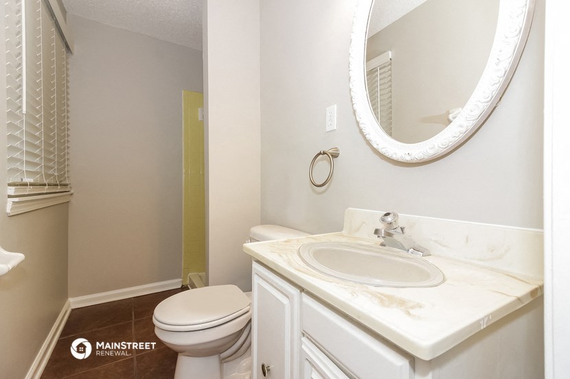 a bathroom with a sink toilet and a mirror