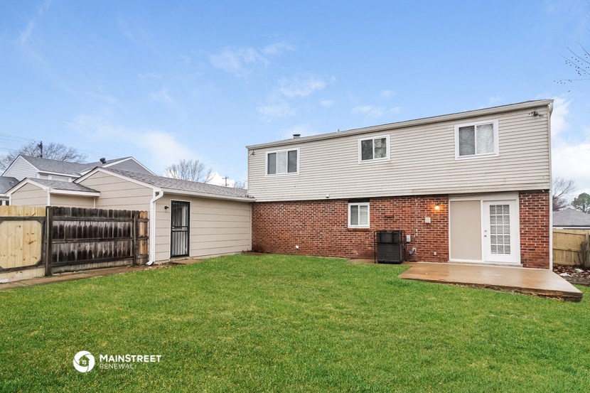 a white house with a yard and a wooden fence