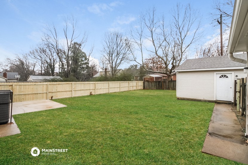 a backyard with a fence and a yard and a shed
