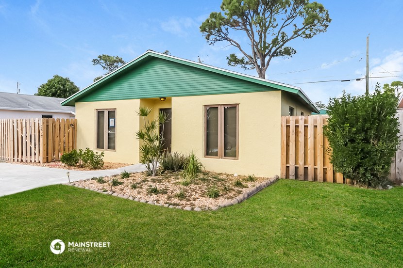 a small house with a yard and a green roof