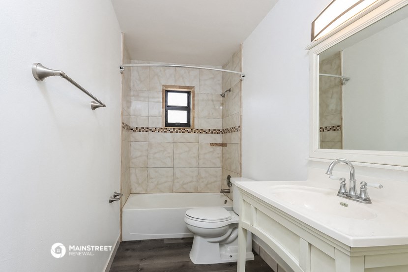 a bathroom with a toilet and a sink and a shower