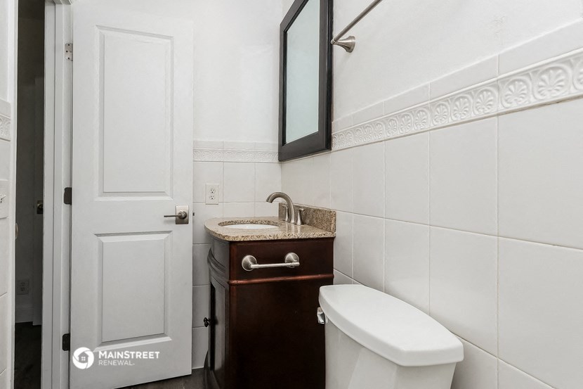 a small bathroom with a toilet and a sink and a mirror