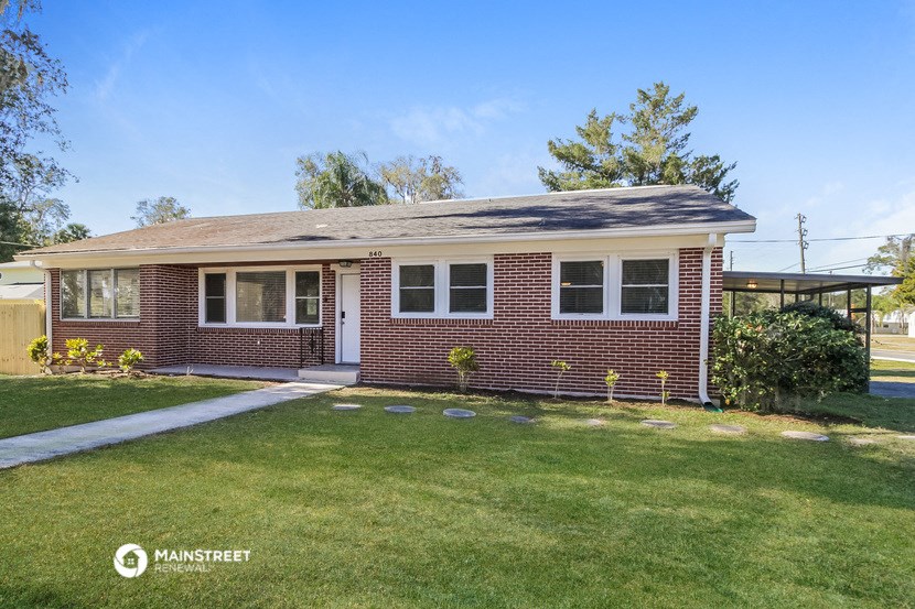 the front of a brick house with a lawn
