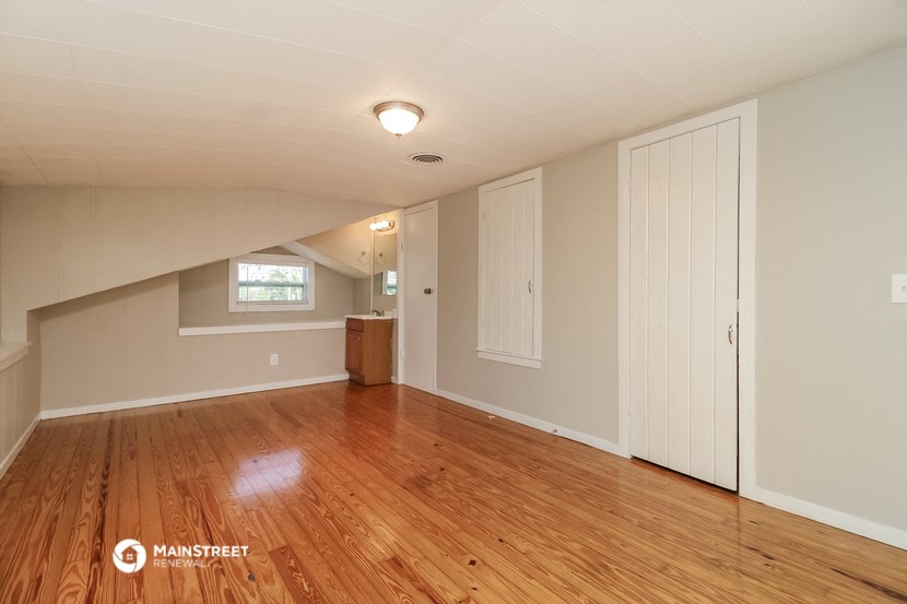 the upstairs living room with wood floors and white walls