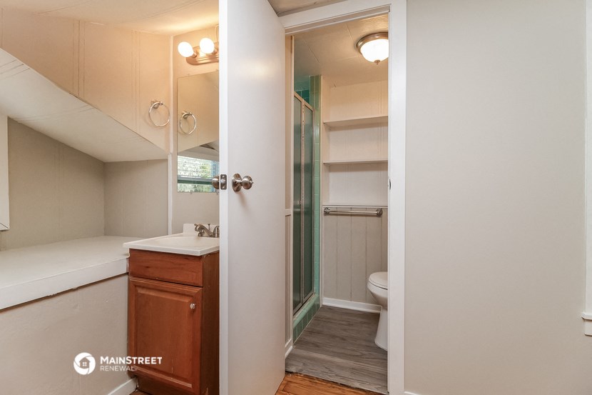 a bathroom with a shower and a sink and a toilet
