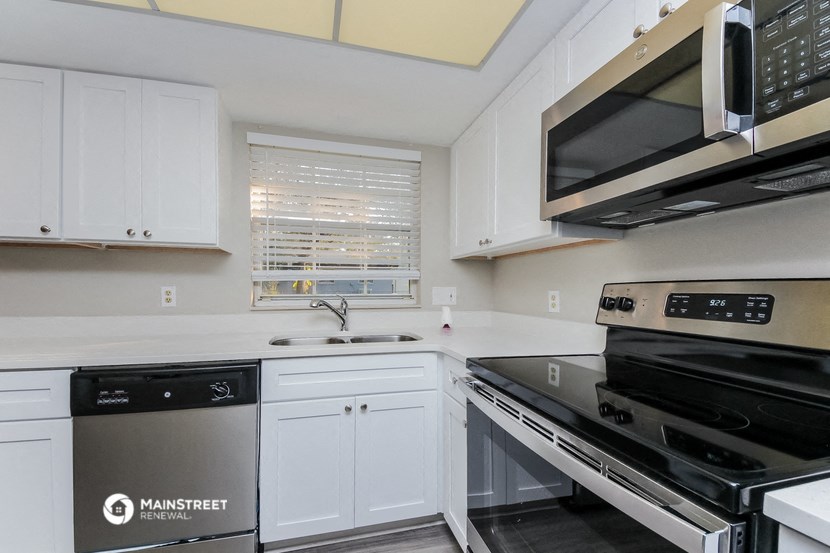 a kitchen with white cabinets and black appliances