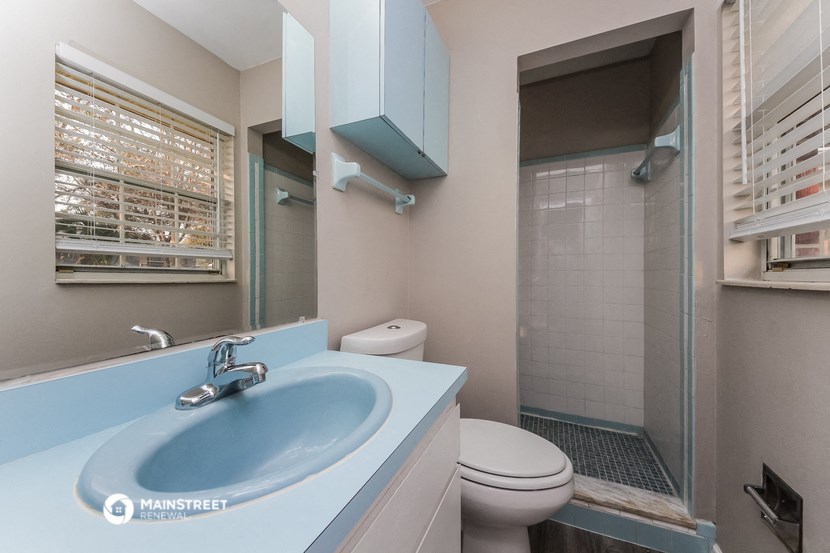a bathroom with a sink and a shower and a toilet