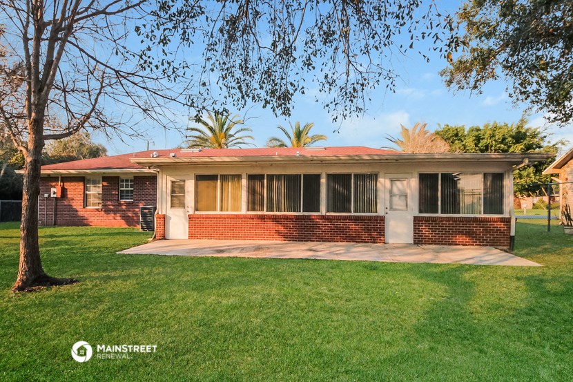 an old brick house with a lawn and a tree