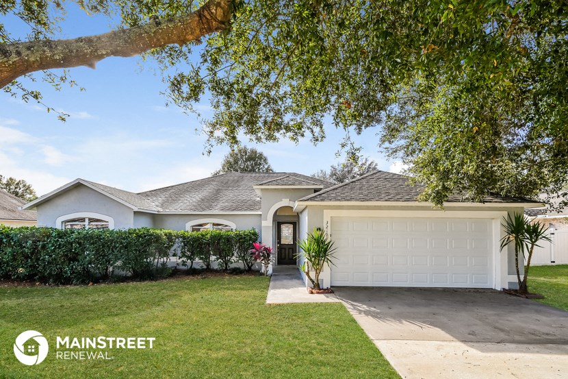 a home with a white garage door and a lawn