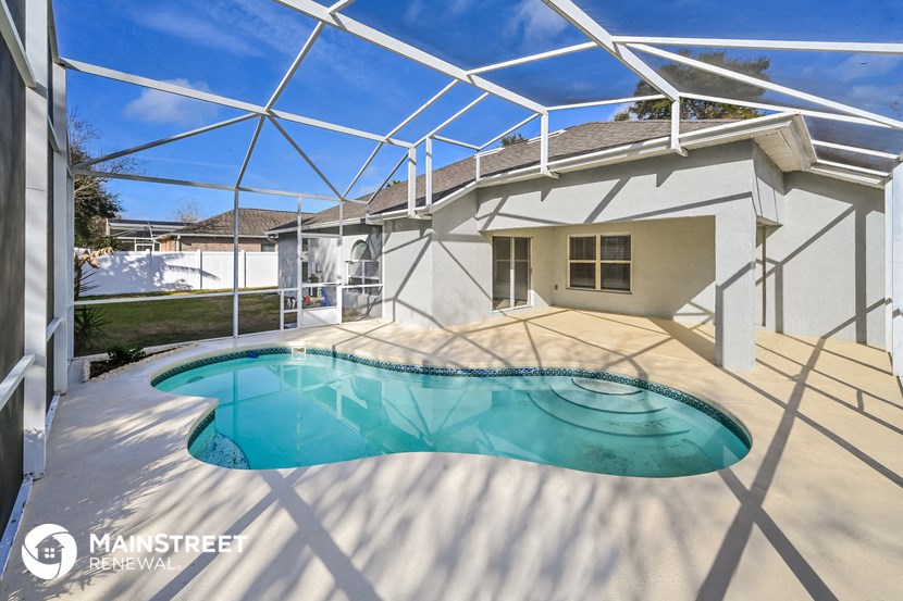 the pool is under an enclosure in the backyard of a house