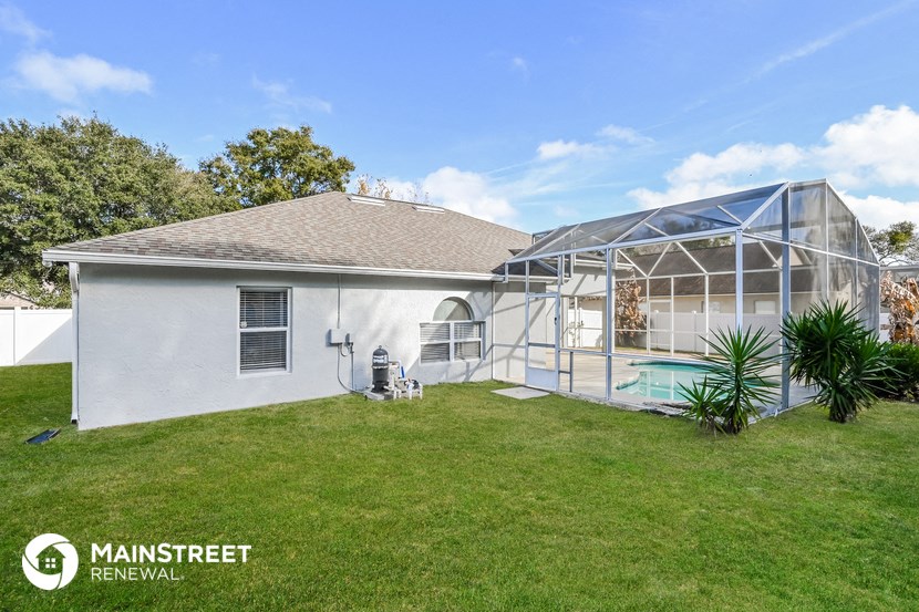 a backyard with a pool and a house with a greenhouse