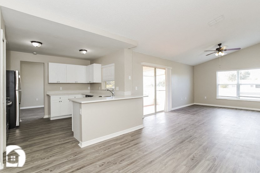 an empty kitchen and living room with a white counter top