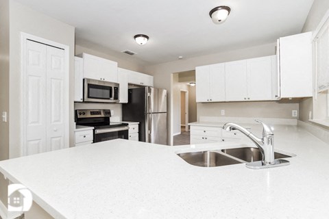 a white kitchen with a sink and a counter top