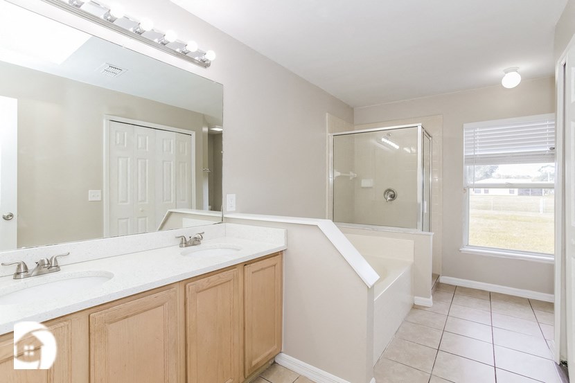 a bathroom with a tub and a sink and a mirror