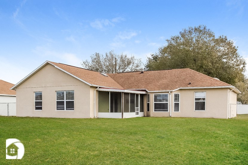 a home with a grass yard and a white house