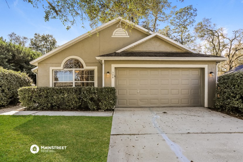 a home with a garage door and a driveway