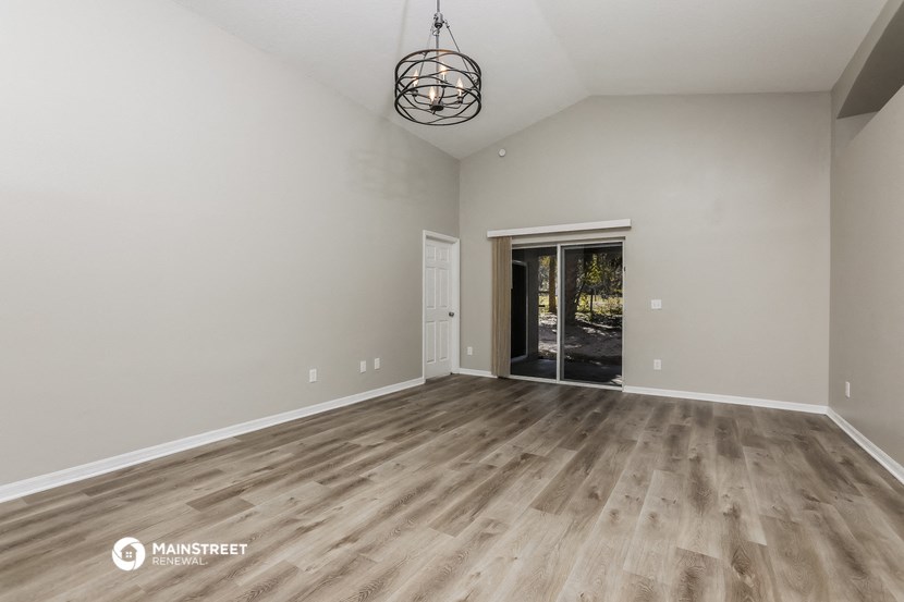 the living room with wood floors and a door to the backyard