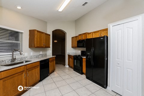 a kitchen with black appliances and wooden cabinets
