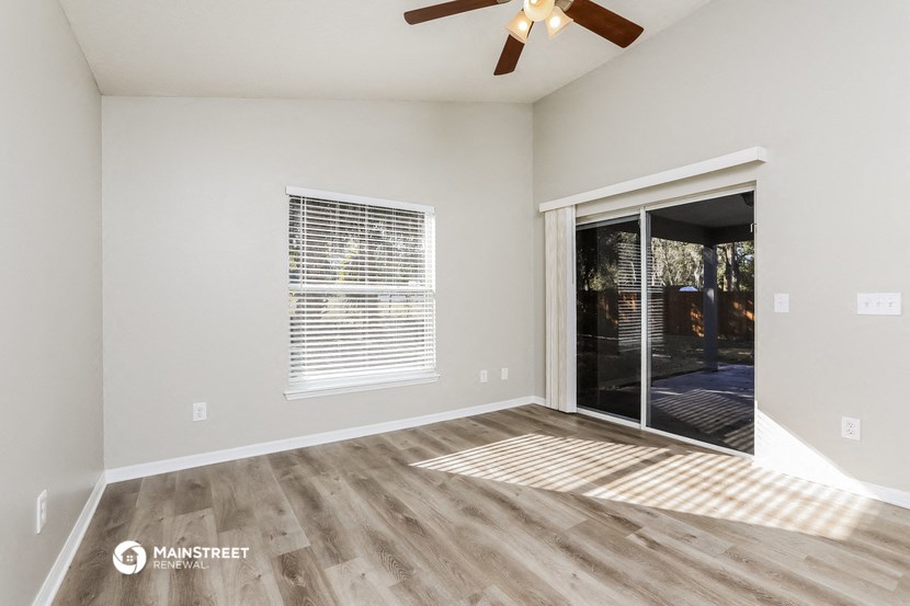 the spacious living room with a sliding glass door to the patio