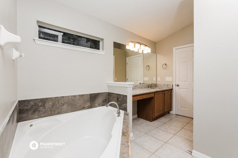 a bathroom with a tub and a sink and a mirror