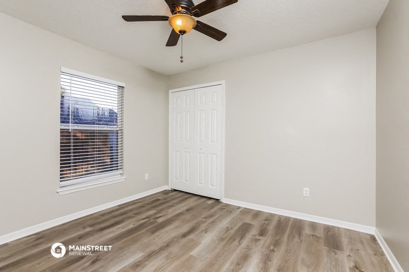 the living room of our studio apartment atrium with a ceiling fan and a window