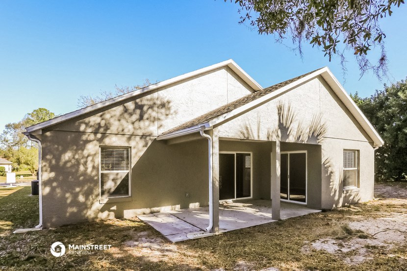 a white house with a porch and a tree