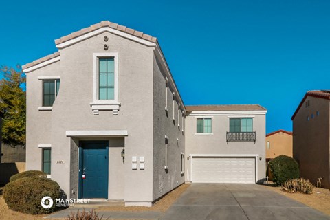 a white brick house with a blue door and a garage