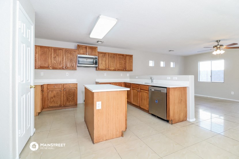 an empty kitchen with wooden cabinets and stainless steel appliances